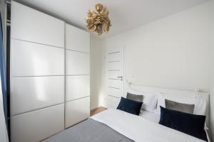 a bedroom with a large white bed with blue pillows at Chmielna Marble City Centre Apartment in Warsaw