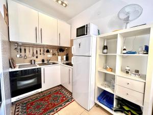 Una cocina con gabinetes blancos y un refrigerador. en Apartment Aida, en Jadranovo 20 fotos más