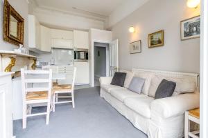 sala de estar con sofá blanco y cocina en Bright 2 bedroom flat with terrace in Notting Hill, en Londres