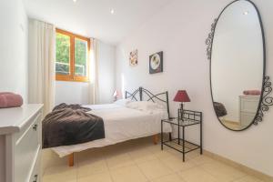 a white bedroom with a bed and a mirror at Casa Nord 10Pax in Caimari