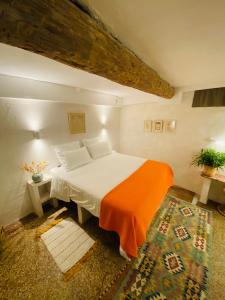 ein Schlafzimmer mit einem großen Bett mit einer orangefarbenen Decke in der Unterkunft L'Atelier in Béziers