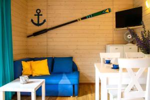 a living room with a blue couch and an anchor on the wall at Domki latonafali in Dąbki