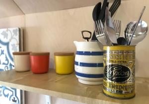 a counter with three colorful containers filled with utensils at St Hilda Beach Hut in Alnmouth