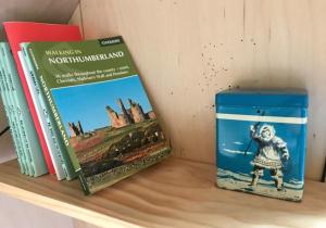two books sitting on top of a shelf at St Hilda Beach Hut in Alnmouth