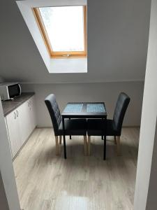 a table and chairs in a room with a window at Pokoje na Górce in Rajgród