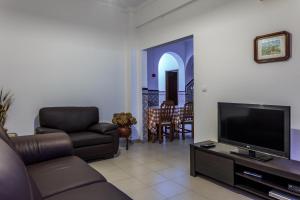 een woonkamer met een bank en een flatscreen-tv bij Ondazul in Zambujeira do Mar