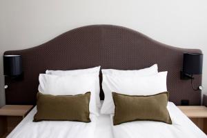 a bedroom with a large bed with white sheets and pillows at Bob W Oslo Sentralen in Oslo