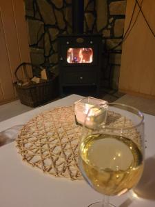 a glass of wine on a table with a fireplace at HENRYKOWO in Stronie Śląskie