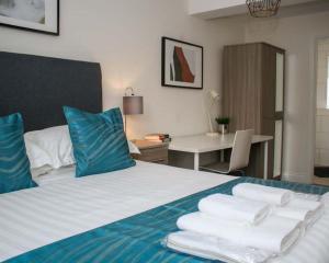 een hotelkamer met een bed met handdoeken erop bij Luxe Living Guest House-Sleeps 6 -Family Friendly-Private Parking-Wifi-City-Beach in Swansea