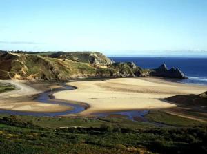 an aerial view of a beach with the ocean at Luxe Living Guest House-Sleeps 6 -Family Friendly-Private Parking-Wifi-City-Beach in Swansea