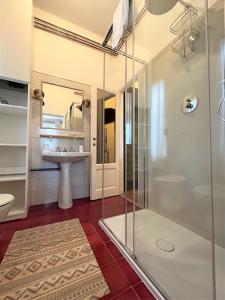 佛罗伦萨Vespucci Florence Studio的带玻璃淋浴和水槽的浴室