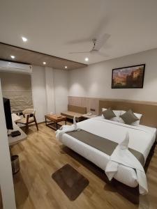 PānchuriaにあるFirangipani Suites - A Corporate Boutique Hotelのベッドルーム(大型ベッド1台付)、リビングルームが備わります。