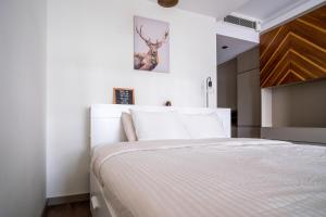 een slaapkamer met een wit bed met een hertenfoto aan de muur bij Furnis in Istanbul