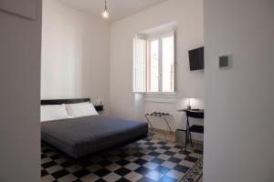 een slaapkamer met een bed en een geruite vloer bij Al Dio Bes in Cagliari