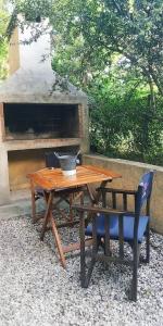 una mesa de madera y un banco junto a un horno de pizza en Departamento duplex en Villa General Belgrano