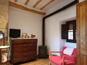 Can vinyals 1979 في La Pobla de Cérvoles: غرفة معيشة مع كرسي احمر وخزانة