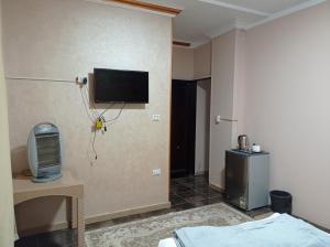 een kamer met een tv aan de muur en een bed bij Royal Pyramids Inn in Caïro