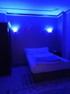 een slaapkamer met een bed met blauwe verlichting bij Royal Pyramids Inn in Caïro
