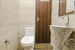a bathroom with a toilet and a sink at FabHotel Sky Lark Farm in Ludhiana