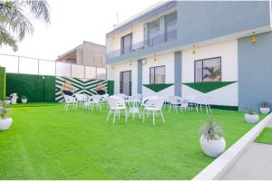 un grupo de sillas y mesas en un césped en FabHotel Sky Lark Farm, en Ludhiana