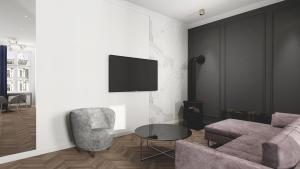 un soggiorno con divano, sedia e TV di Deco Apartments Mariacka 8 a Katowice