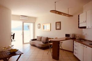 uma cozinha e sala de estar com um sofá e uma mesa em Boka Residence 8 em Herceg Novi
