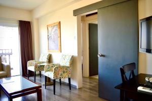 um quarto com duas cadeiras, uma mesa e uma porta em Lordos Hotel Apartments Nicosia em Nicósia