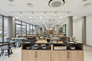 a restaurant with a counter with food on it at All Suites Noisy Le Grand in Noisy-le-Grand