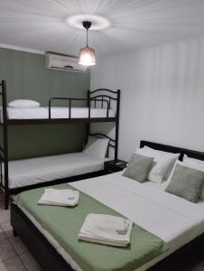 Dos camas en una habitación con toallas. en Studios Dimitraki en Skala Rachoniou