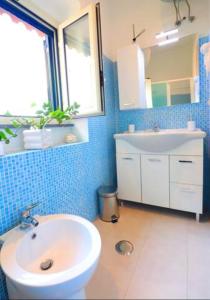 ein Badezimmer mit einem weißen Waschbecken und einem Spiegel in der Unterkunft Casa Ninà in Sant'Agnello