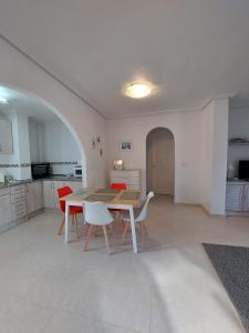 cocina y comedor con mesa y sillas en L.A. Apartment, en Los Alcázares