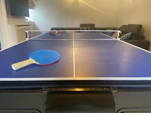 a ping pong table with a ping paddle on it at Llanfair Hall, Dog Friendly, Cinema, Games Room, Hot Tub in Llanfairpwllgwyngyll