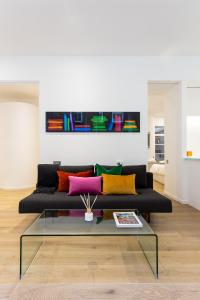 a living room with a black couch with colorful pillows at 2 Bed 2 Bath Apartment Off Regent Street in London