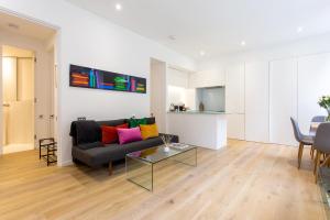 a living room with a couch and a table at 2 Bed 2 Bath Apartment Off Regent Street in London