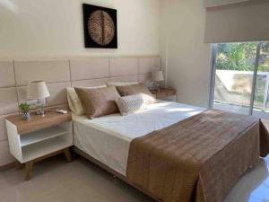 - une chambre avec un grand lit, une table de chevet et une fenêtre dans l'établissement Apart-Hotel de Lujo en Eje Corporativo de Asunción! 2 y 3 habitaciones, à Asuncion