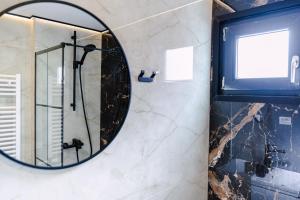 a mirror in a bathroom with a shower at Moon Resort in Buşteni