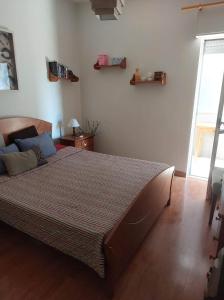 Un dormitorio con una cama grande y una ventana en Casa de Praia, en Paço de Arcos