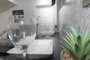 two wine glasses sitting on a table in a room at Studio 2 min walk to Upton Park Station in London