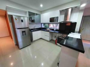 a kitchen with a stainless steel refrigerator and white cabinets at Apart-Hotel de Lujo en Eje Corporativo de Asunción! 2 y 3 habitaciones in Asuncion