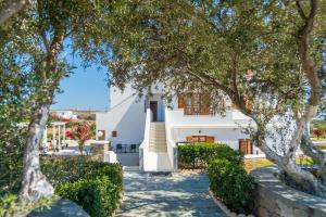 a white house with trees in front of it at Konstantinos in Adamantas