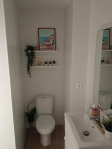 een witte badkamer met een toilet en een wastafel bij Studio vue mer in Benalmadena Costa