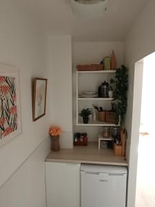 uma cozinha com prateleiras brancas e um balcão em Studio vue mer em Benalmadena Costa