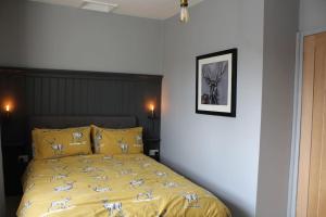 - une chambre dotée d'un lit jaune avec des animaux dans l'établissement Bumblebee Cottage nestled in stunning countryside., à Barrowford