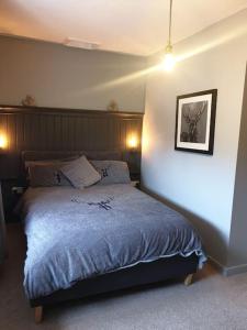 - une chambre avec un lit et une couette bleue dans l'établissement Bumblebee Cottage nestled in stunning countryside., à Barrowford