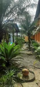 um pátio com palmeiras e um edifício em Pousada Boramar em Boraceia