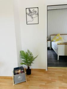 een kamer met een slaapkamer met een bed en een plant bij Ferienwohnung Hotel Glockenhof in Eltville
