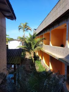 a building with a palm tree in front of it at Pousada Boramar in Boracéia