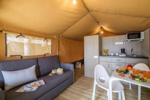 una sala de estar con sofá y mesa en una tienda en Camping Torre de la Mora, en Tamarit