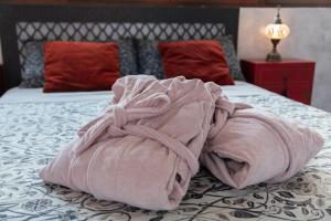 una manta rosa sobre una cama en RIAD MEDINA MUDEJAR BAÑOS ARABES, en Toledo