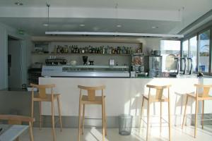 a kitchen with a bar with four stools at Hotel Las Palmas in Carboneras